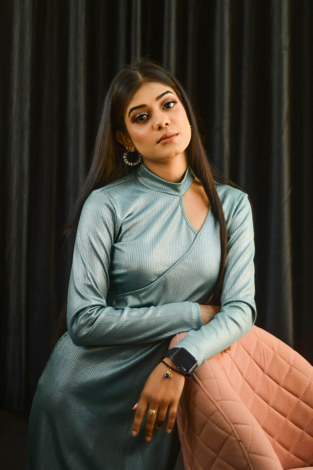 a woman in a blue dress sitting on a chair