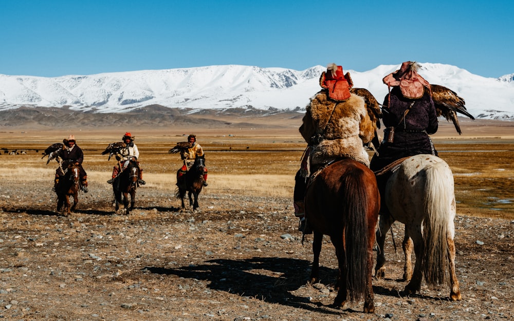 a group of people riding on the backs of horses