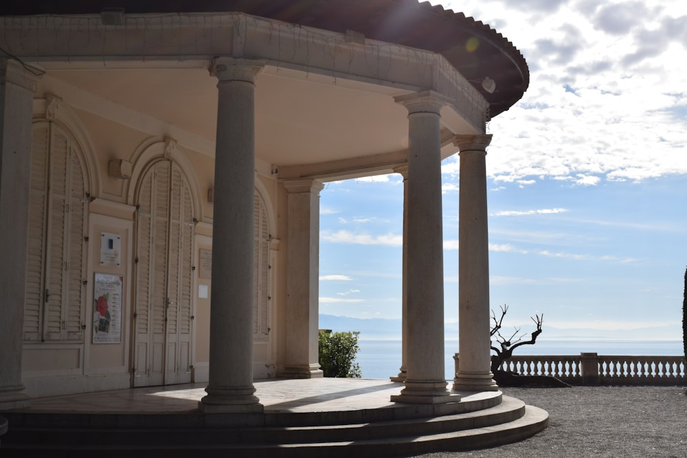 a building with columns and a view of the ocean