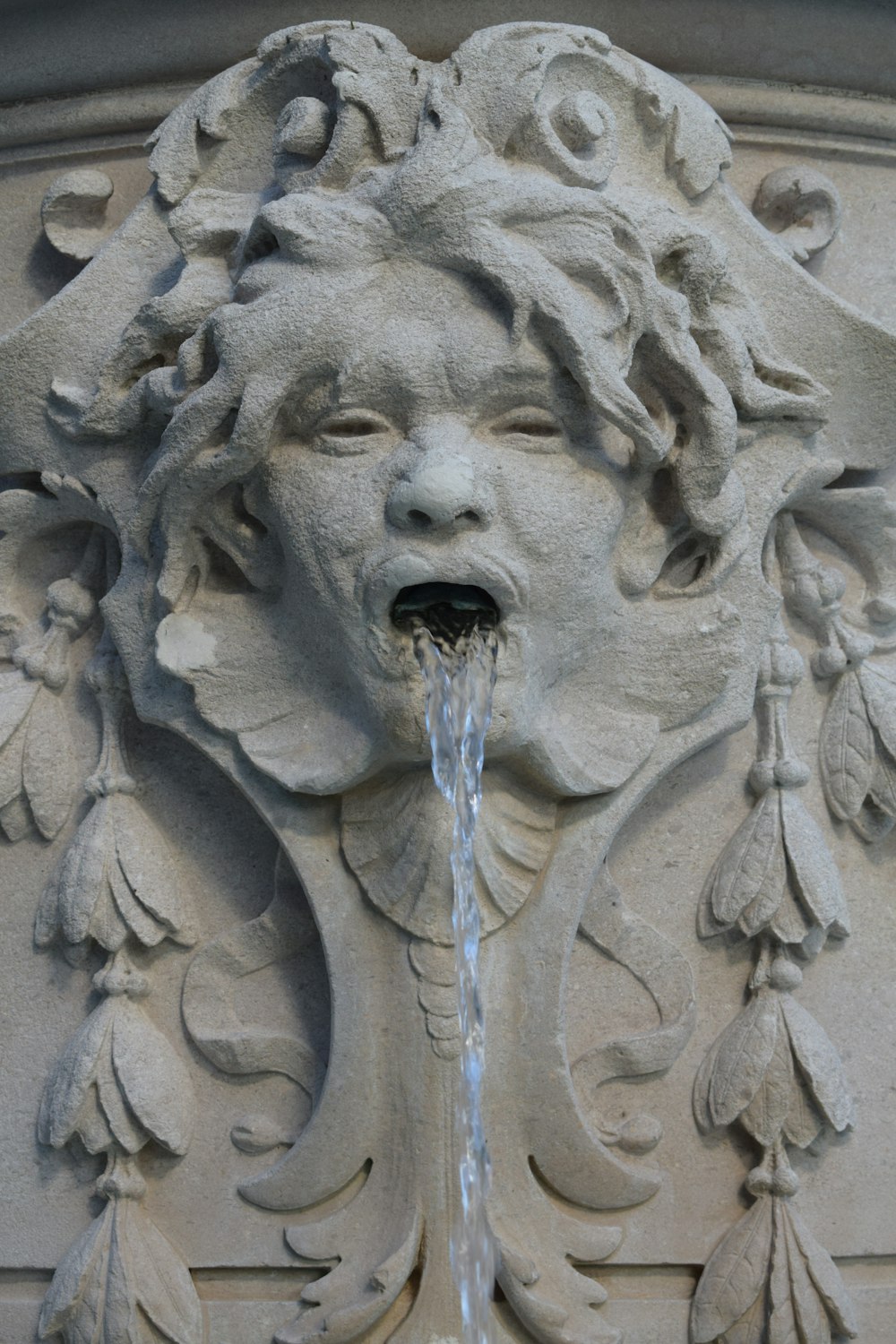 um close up de uma fonte de água com um rosto sobre ele