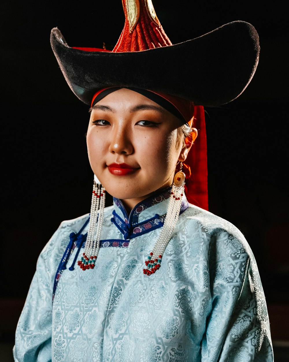 a woman wearing a hat with tassels on her head