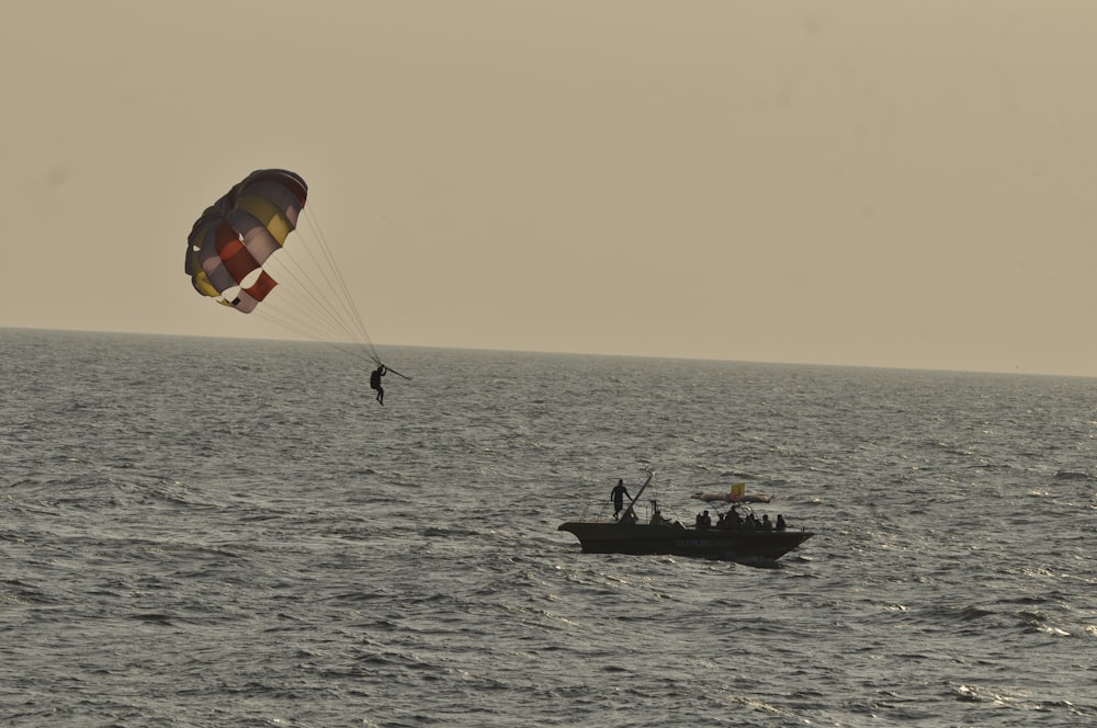 a person parasailing in the ocean with a boat in the background