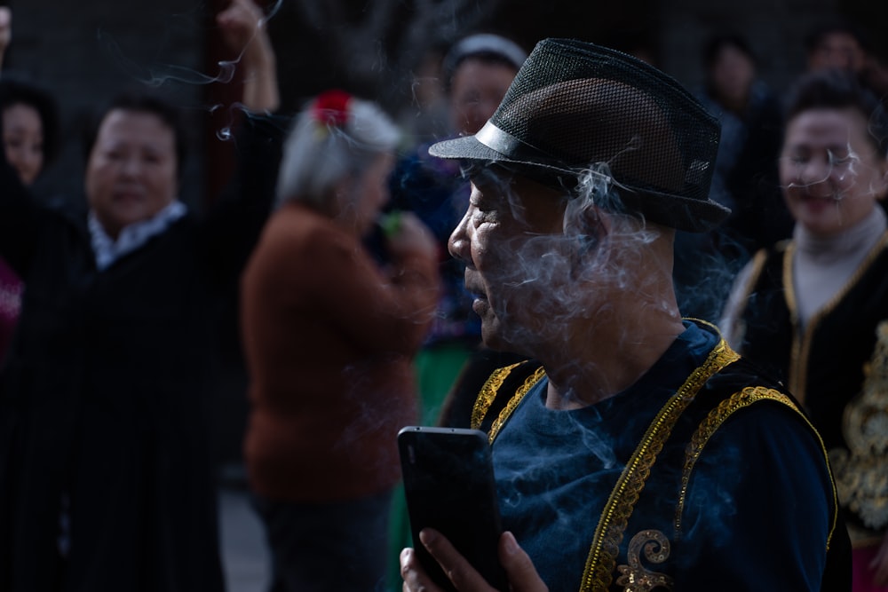 a man smoking a cigarette while looking at his cell phone