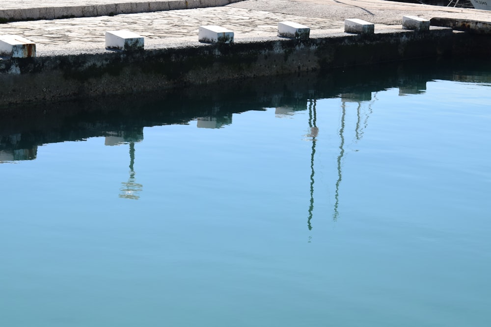 a body of water next to a stone wall