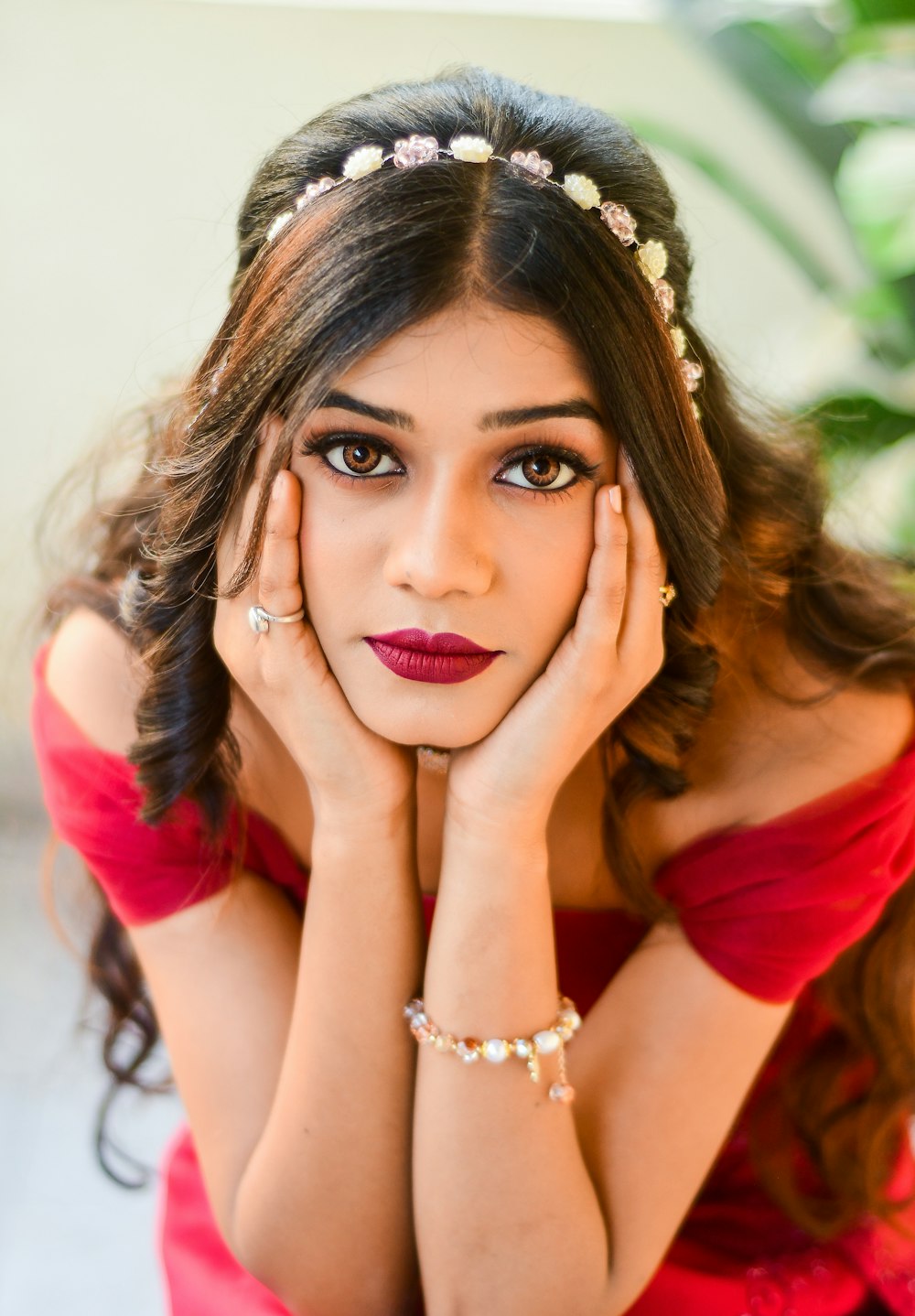 a woman in a red dress with her hands on her face