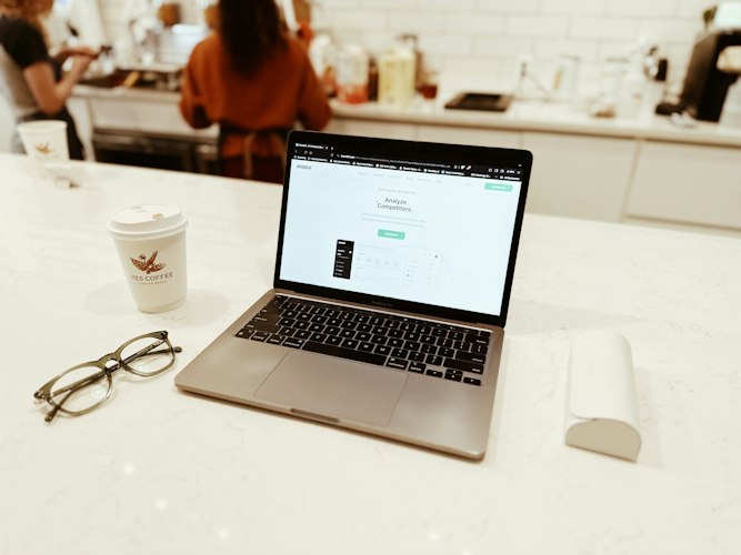 Entrepreneur working on a laptop with charts and workflow diagrams displayed on screen