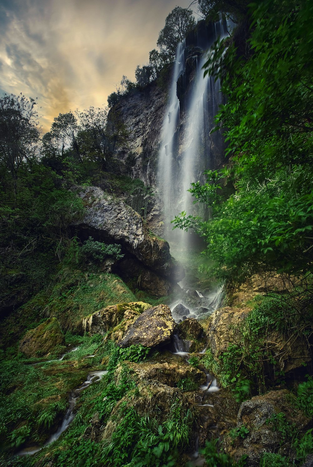 a waterfall in the middle of a lush green forest