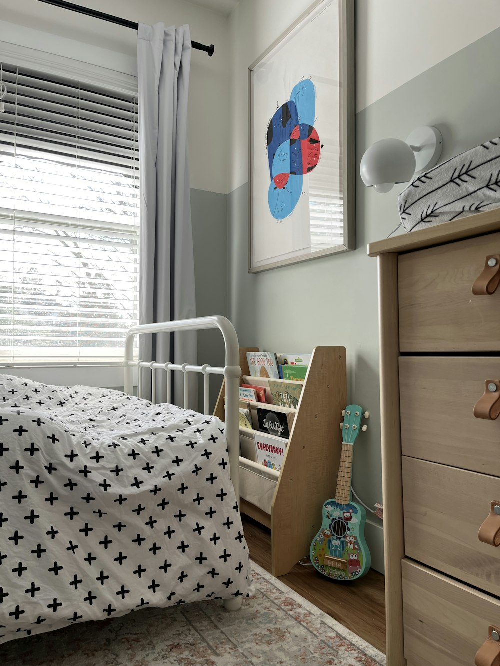 a bedroom with a bed, dresser, and window