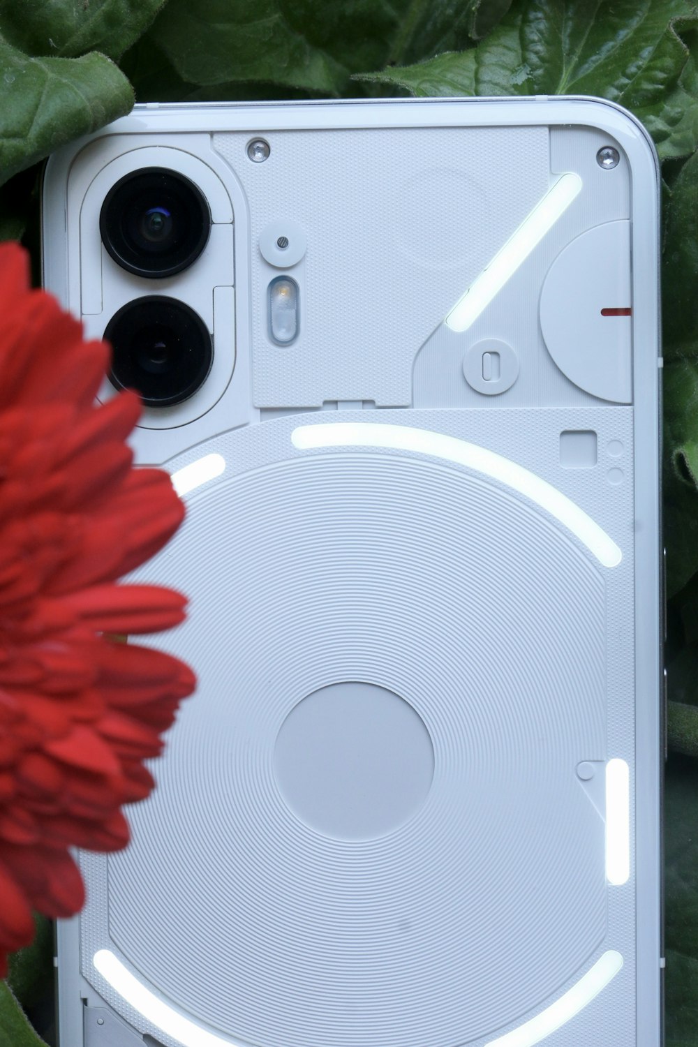 a close up of a cell phone near a flower