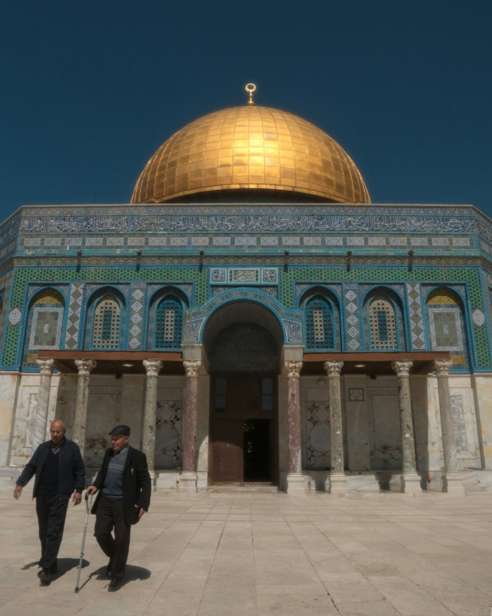 two men walking in front of a building with a golden dome