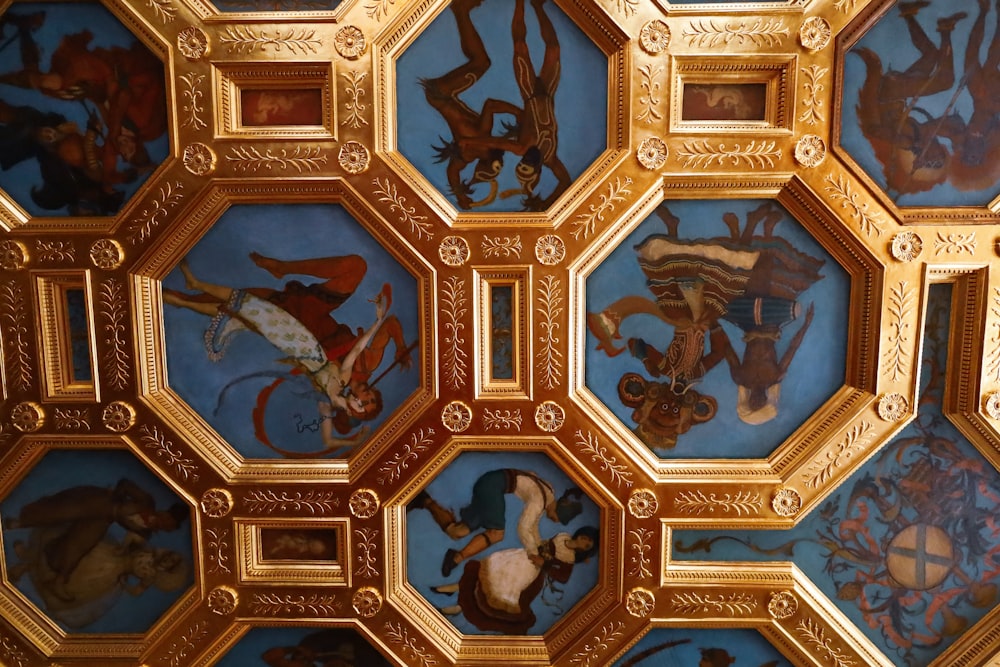 a close up of a ceiling with paintings on it