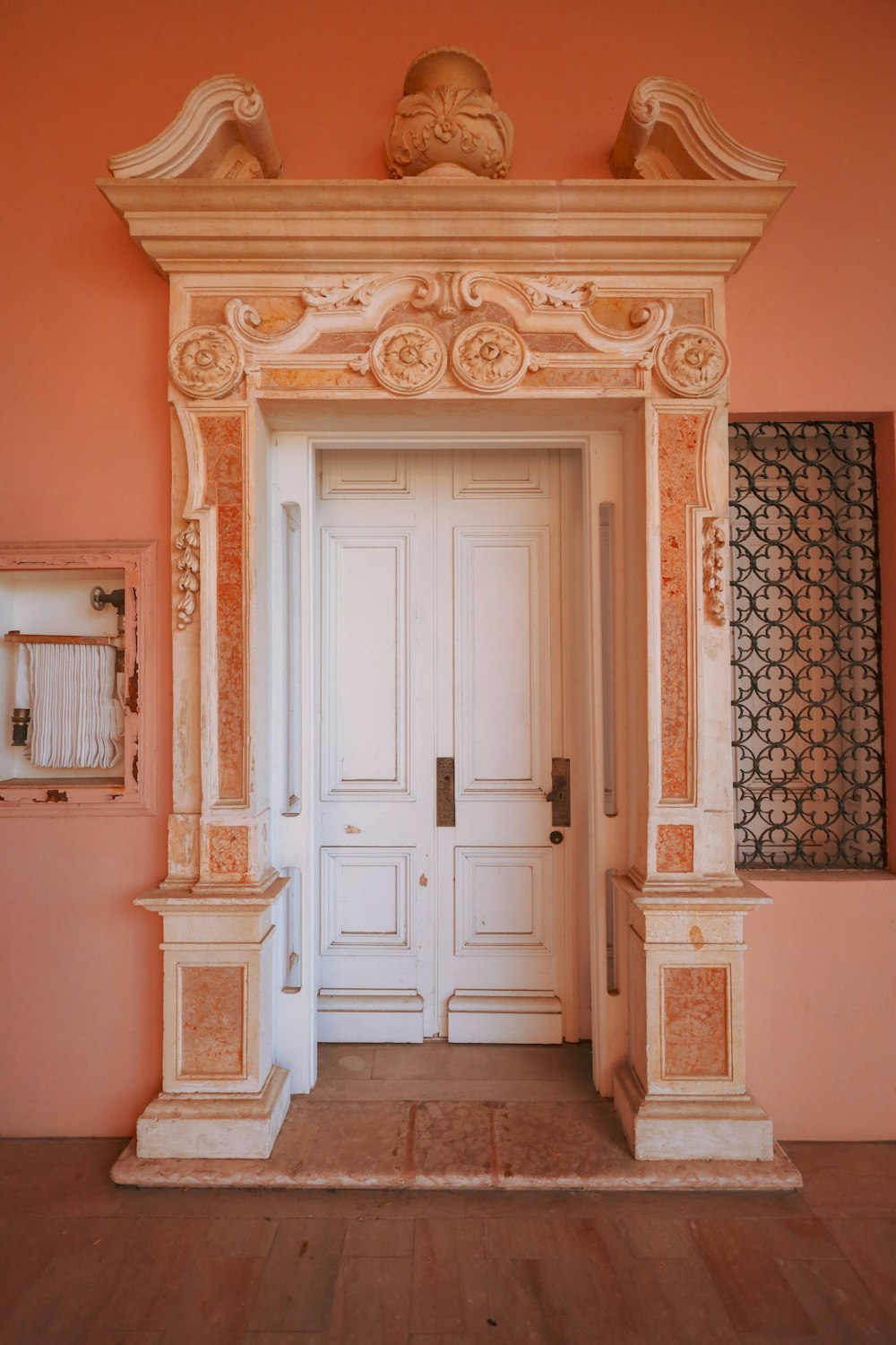 uma porta branca em um quarto rosa com uma pintura na parede