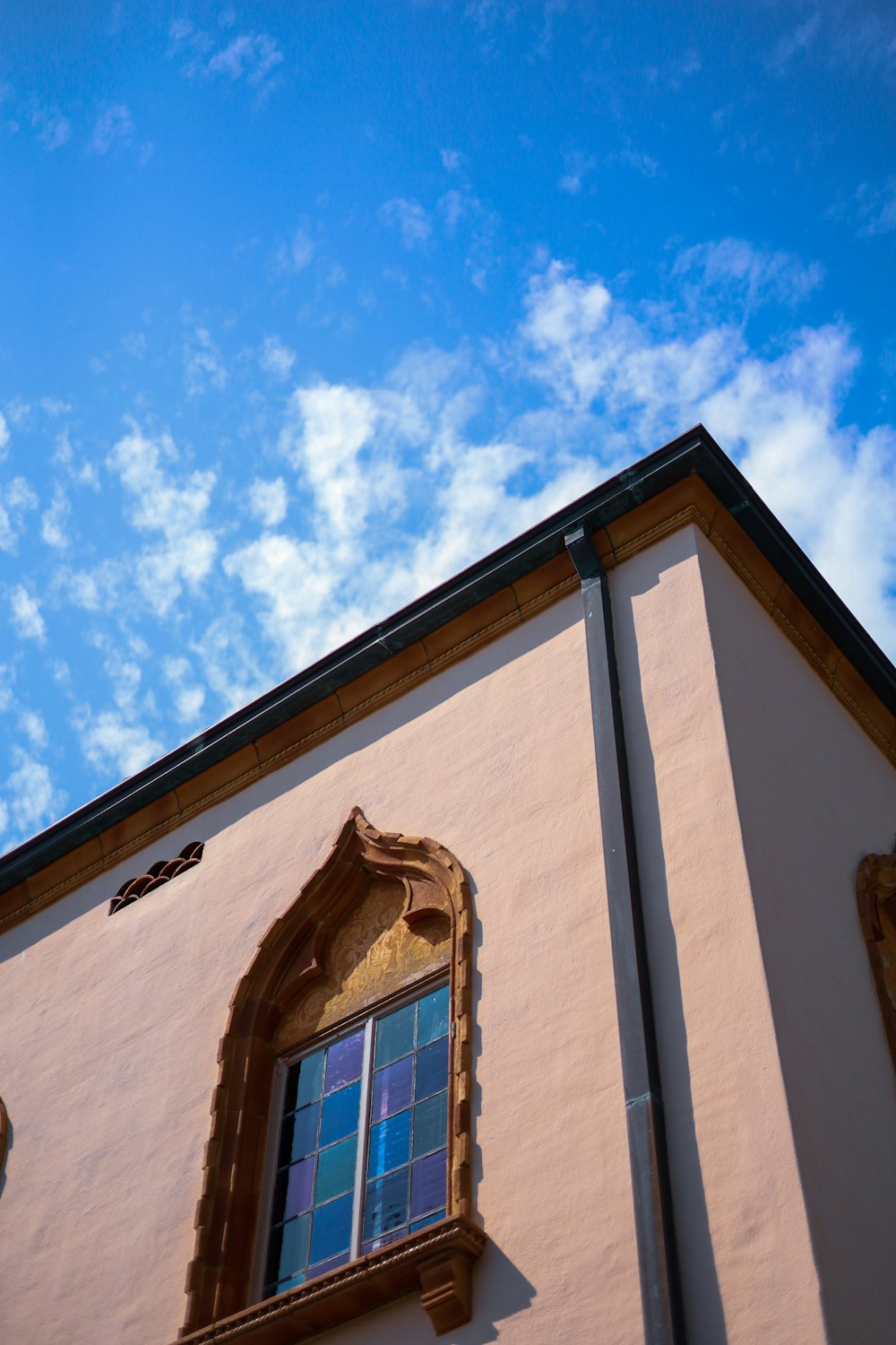 a building with a blue sky and clouds in the background