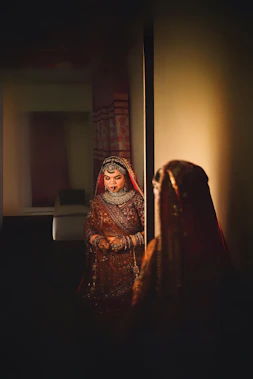 a woman in a red and gold bridal outfit