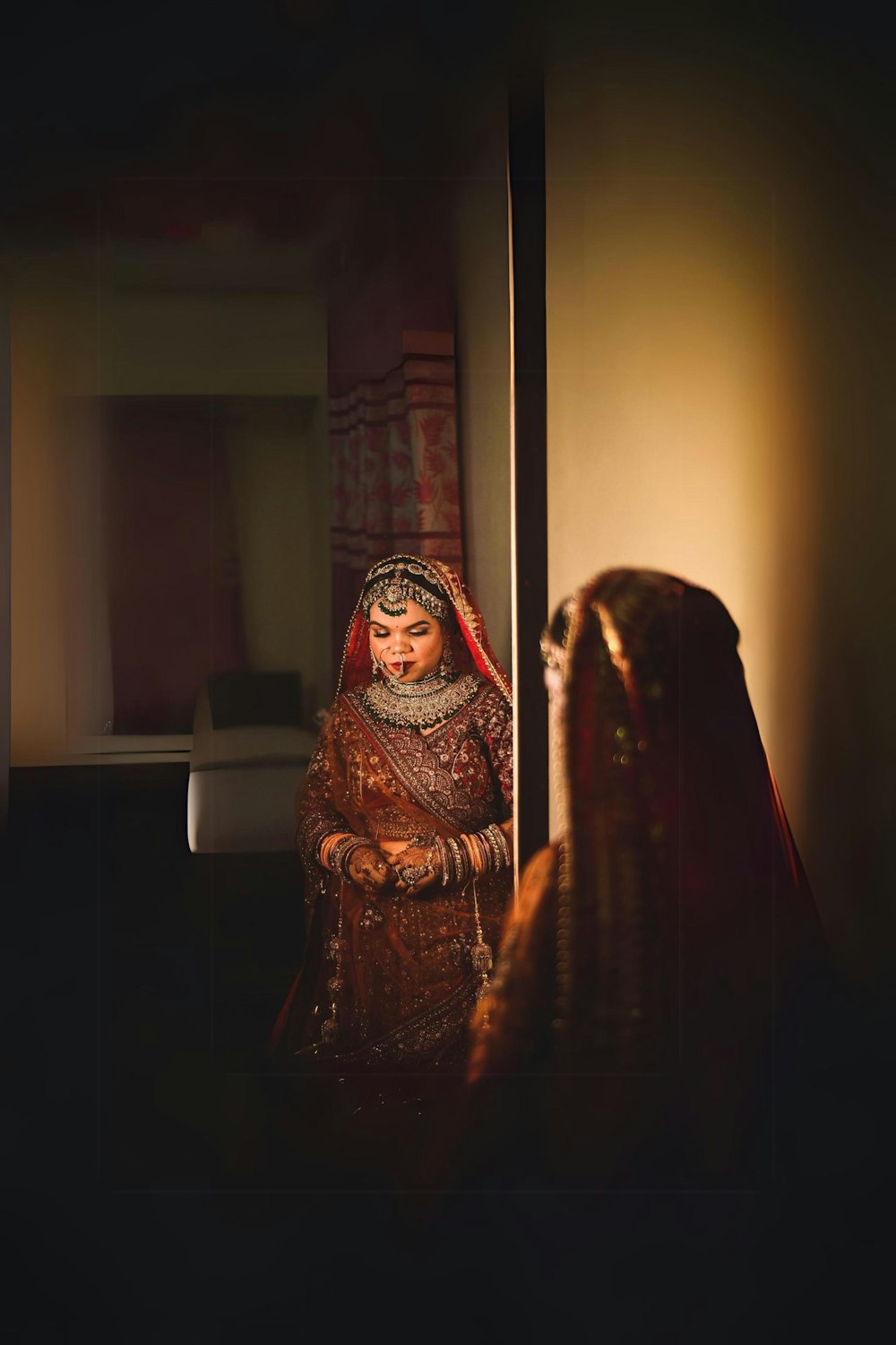 a woman in a red and gold bridal outfit