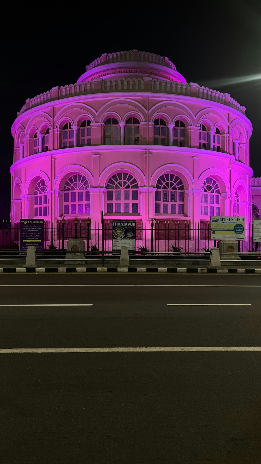 a large pink building lit up at night