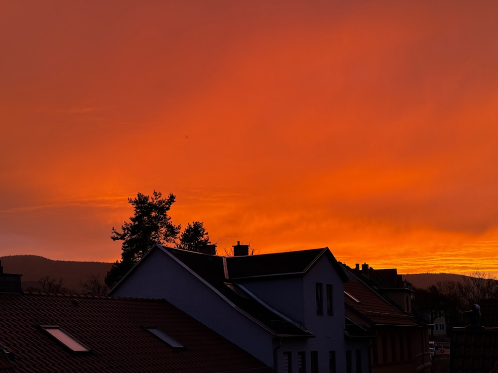 a red sky is seen over some houses