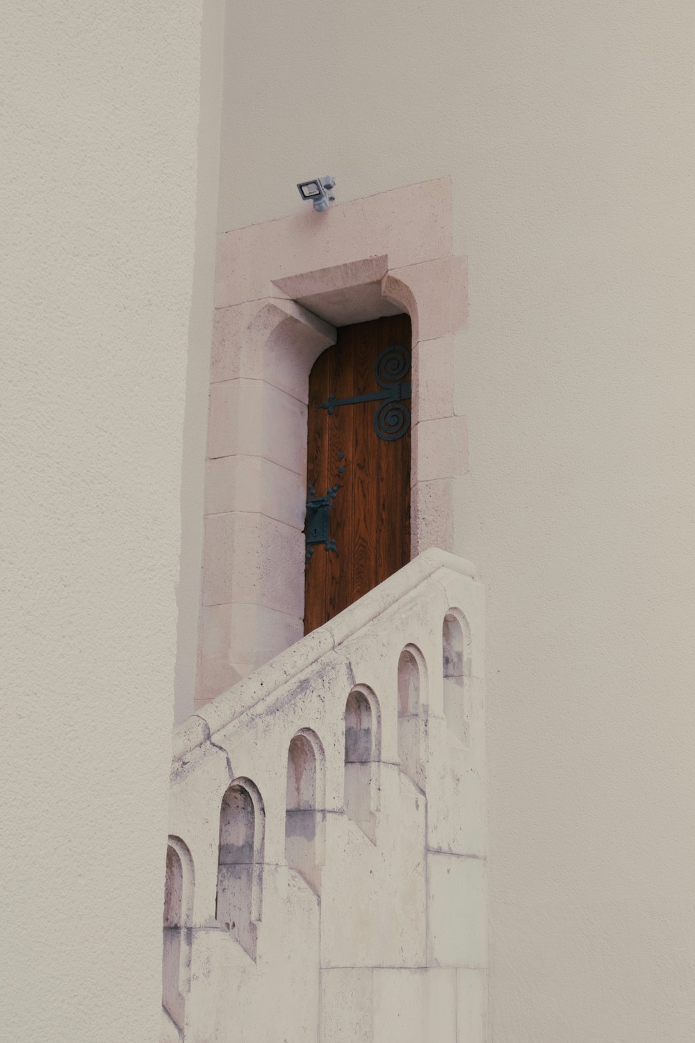 a wooden door in the side of a white building