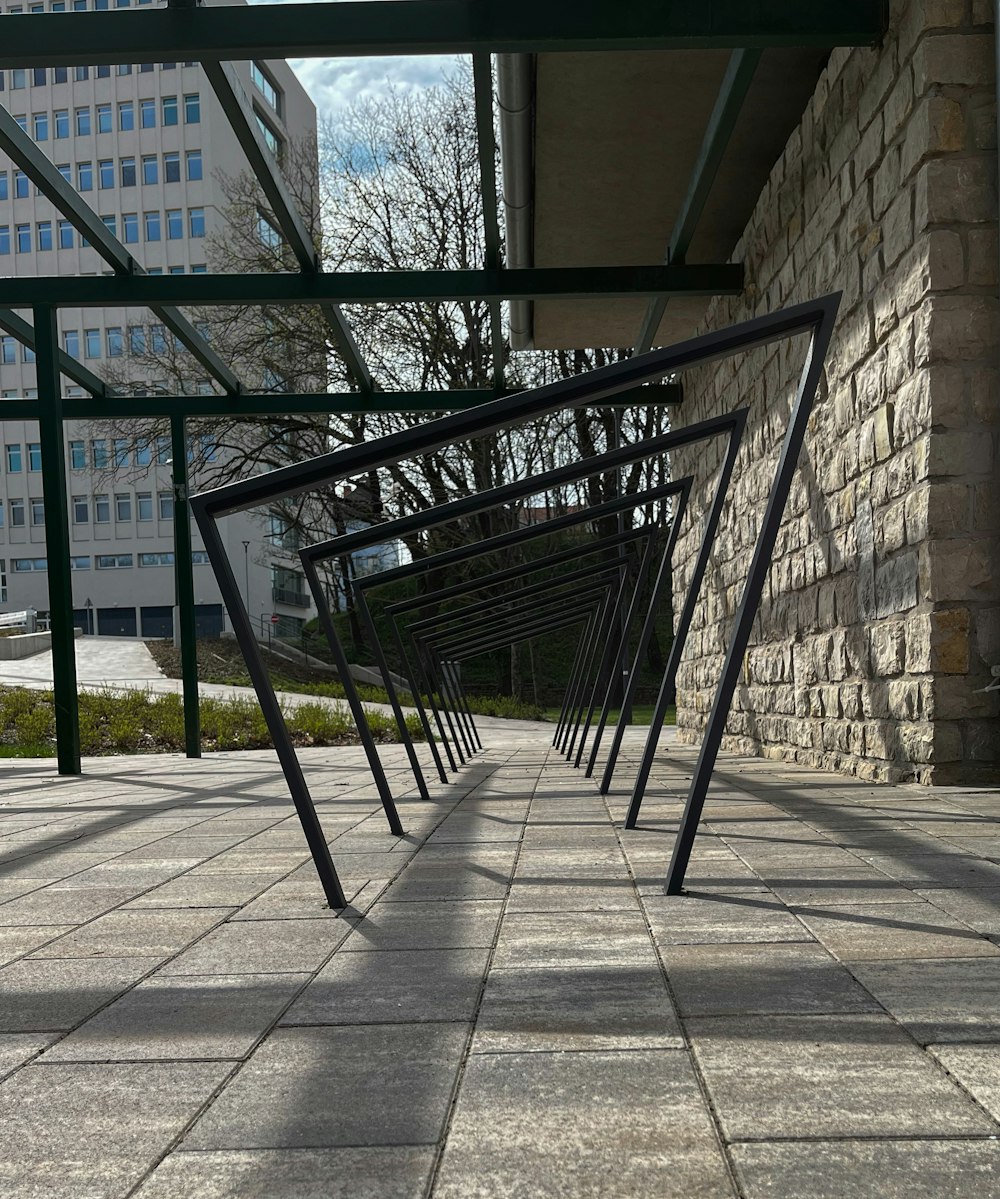 a row of black metal bars sitting on top of a sidewalk