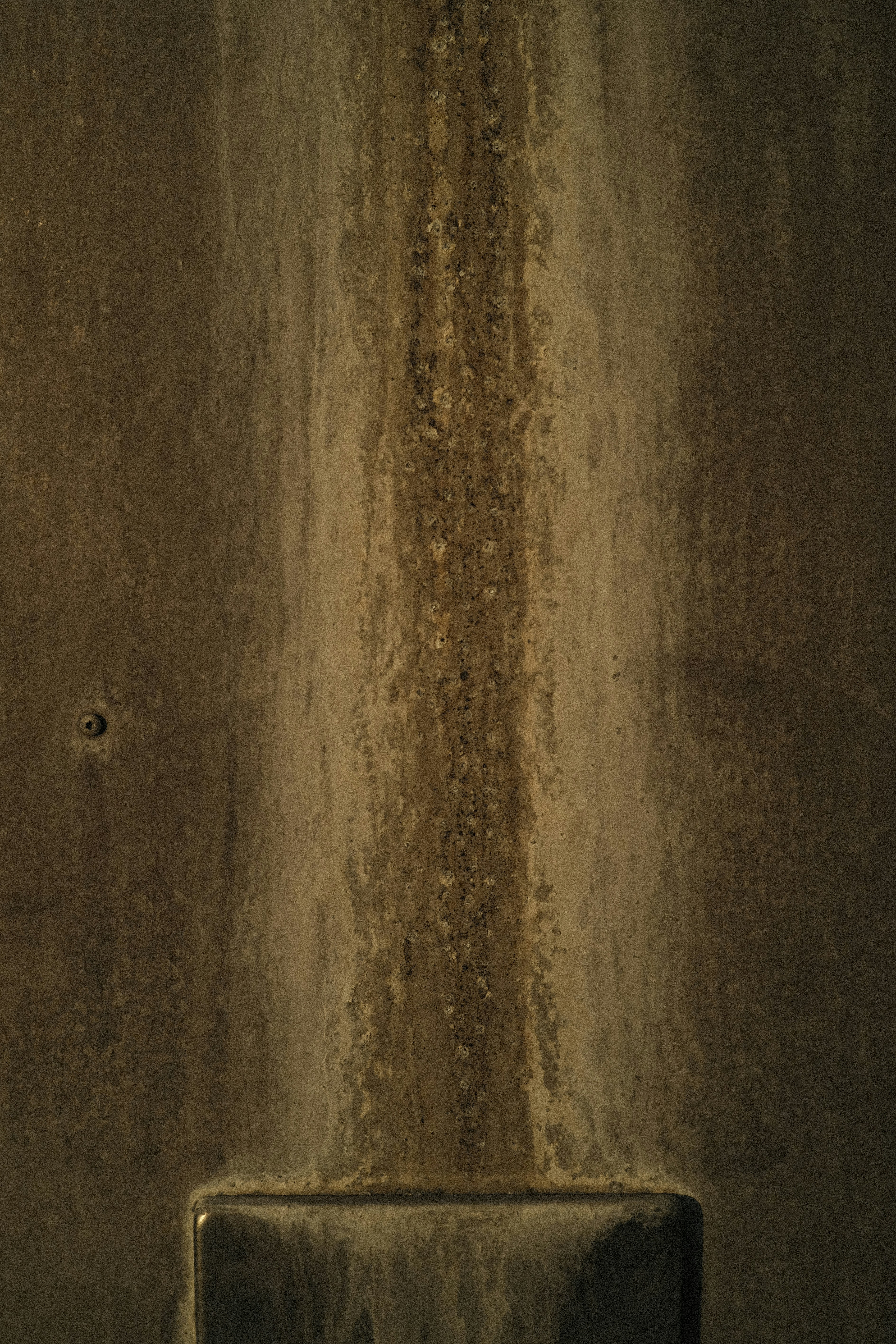 a bathroom with a urinal in the middle of it