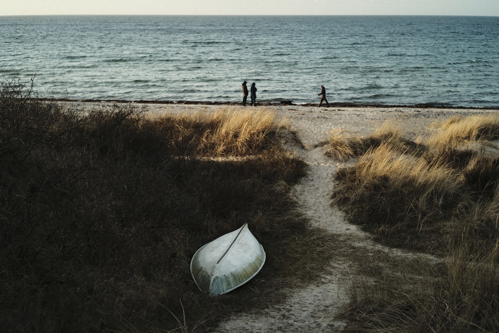 a boat sitting on top of a sandy beach