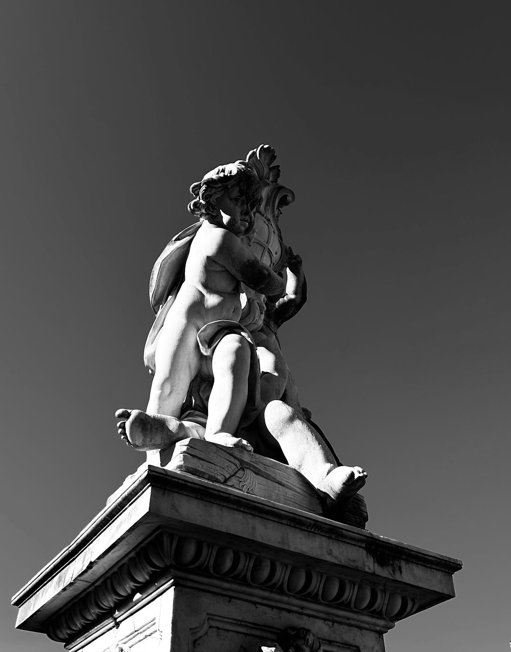 a black and white photo of a statue on top of a building