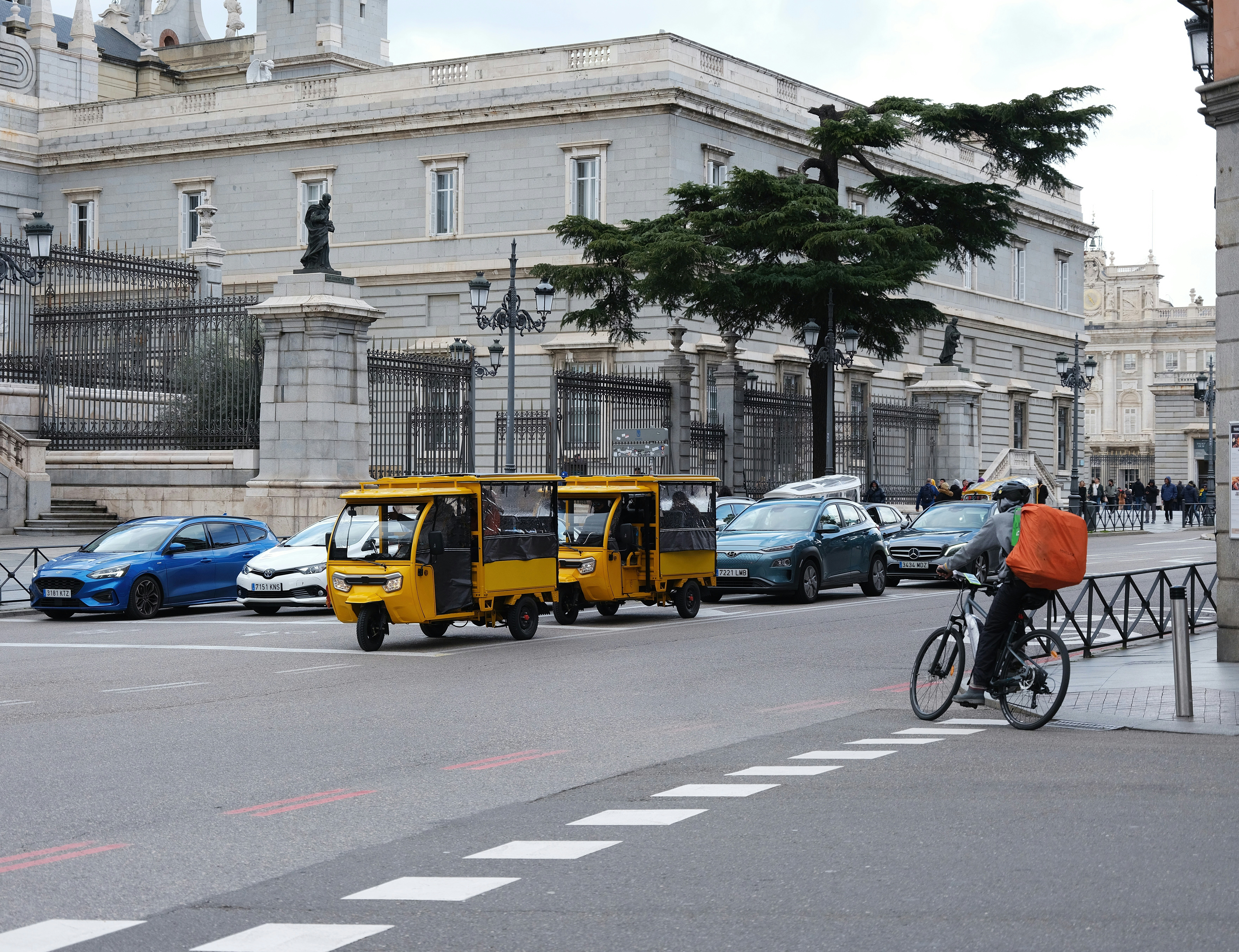 a man riding a bike next to a yellow bus