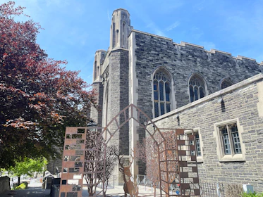 a tall building with a clock tower next to a tree
