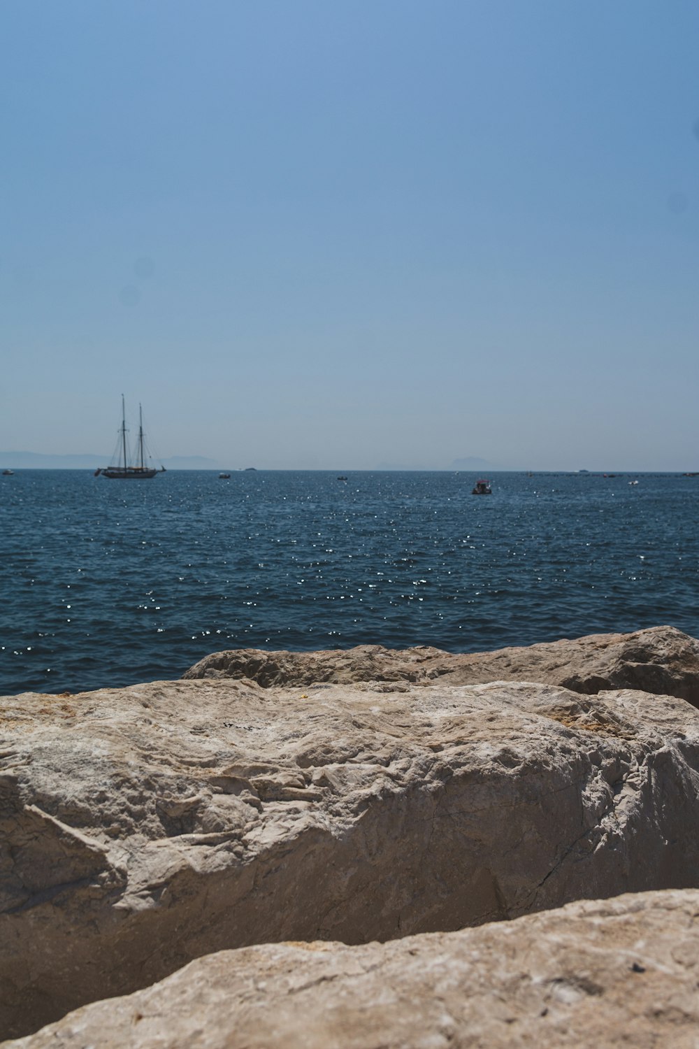 a sailboat is out in the distance on the water