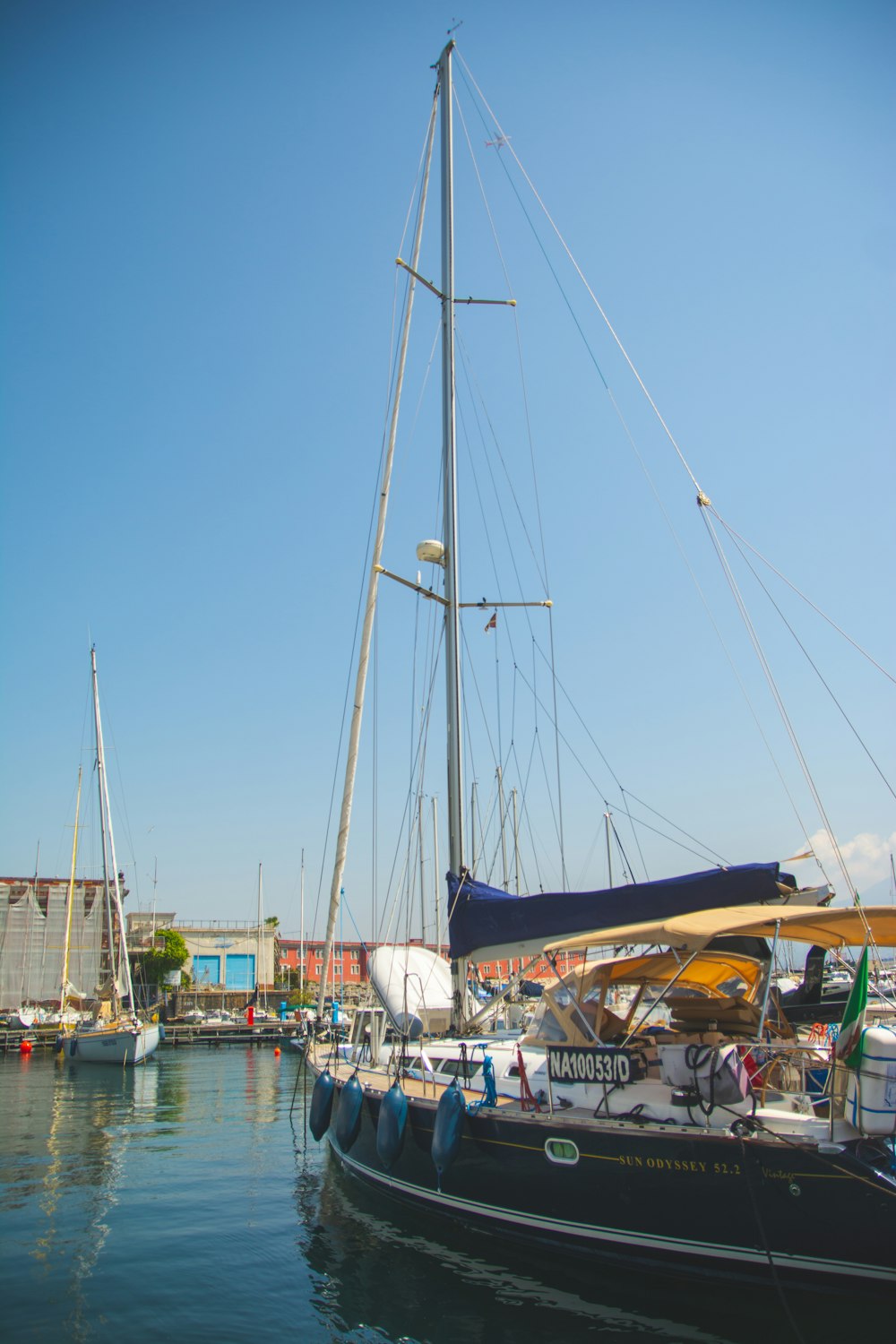 a sailboat in the water with other boats in the background