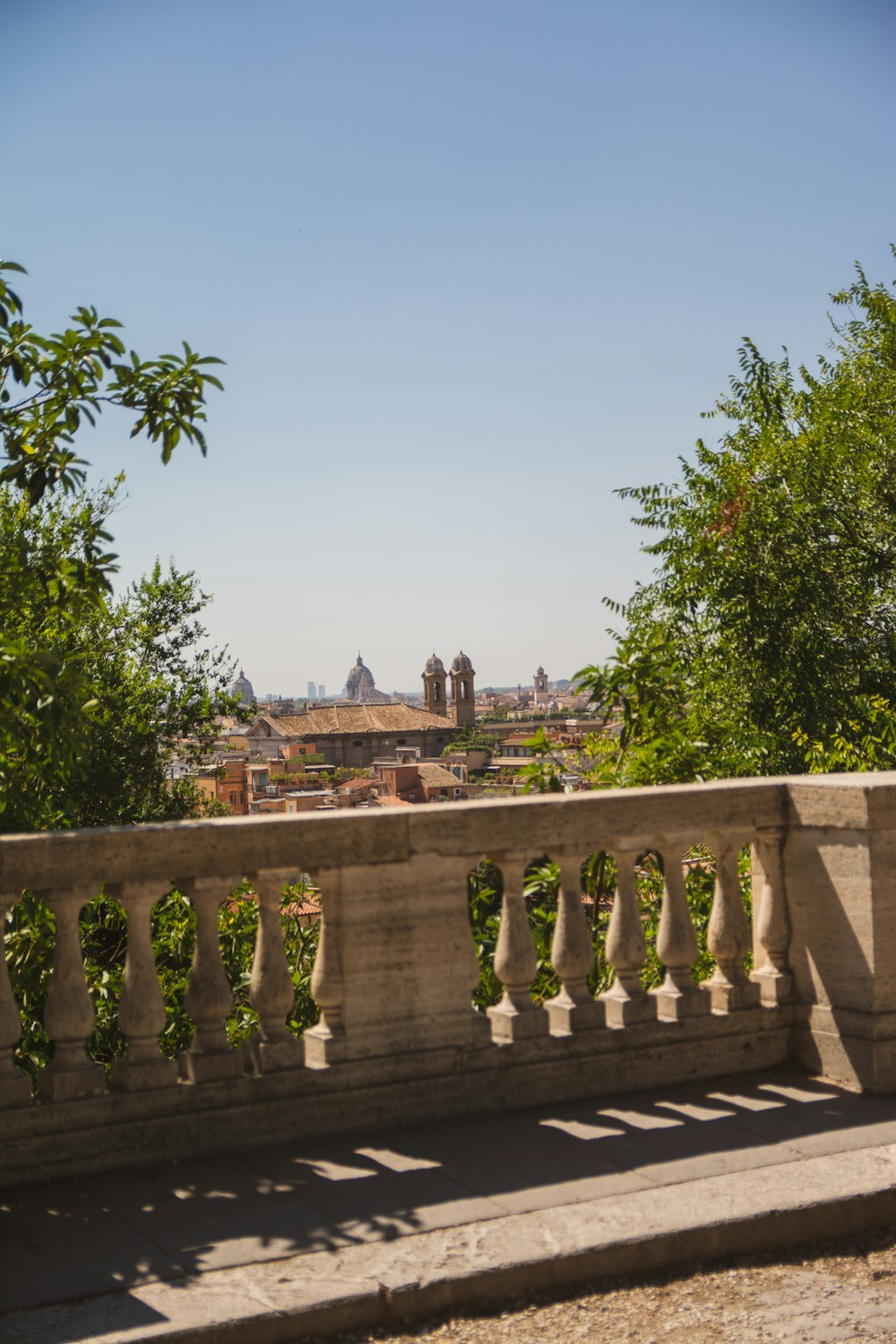 a stone bench with a view of a city in the distance