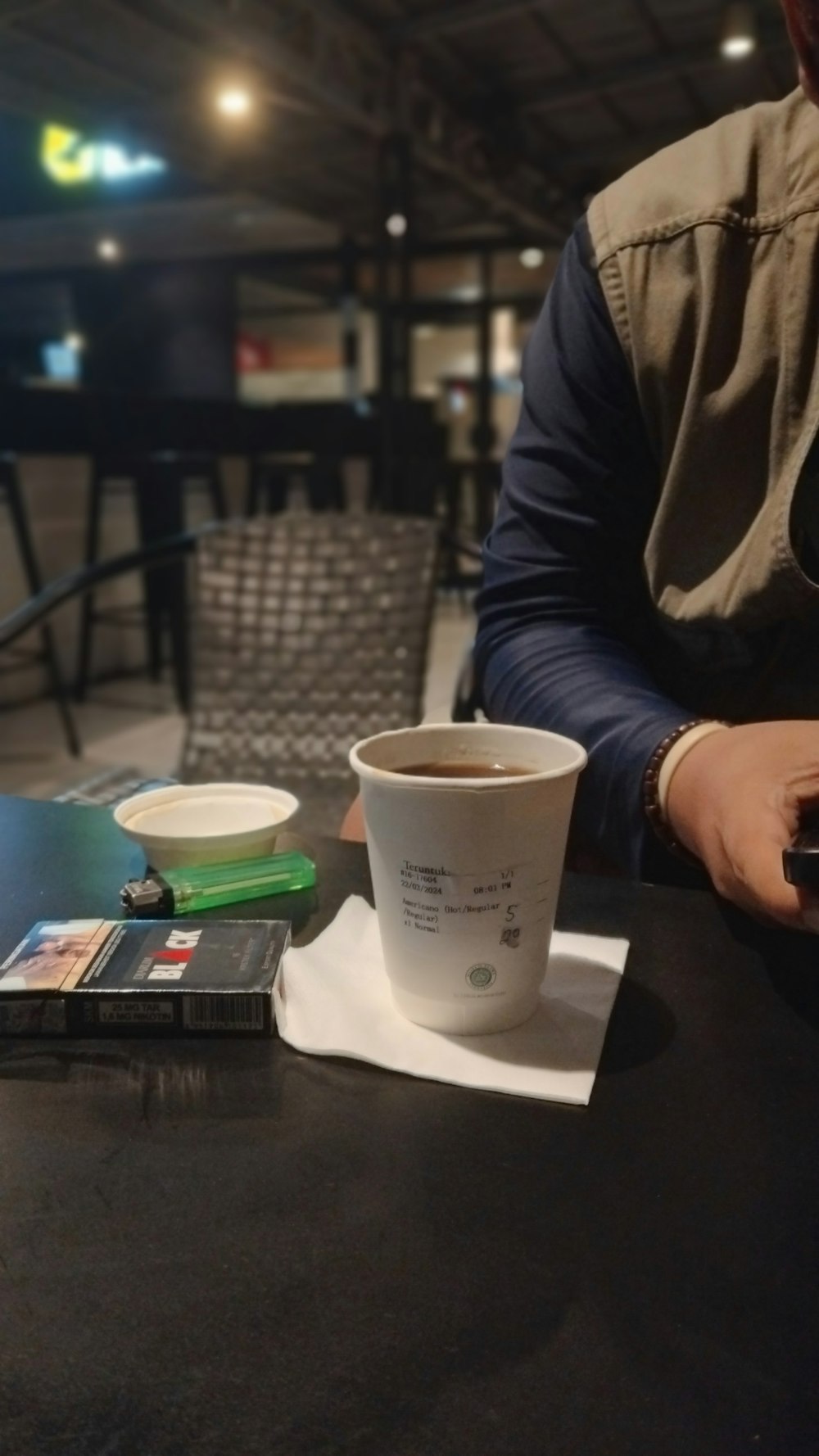 a man sitting at a table with a cup of coffee