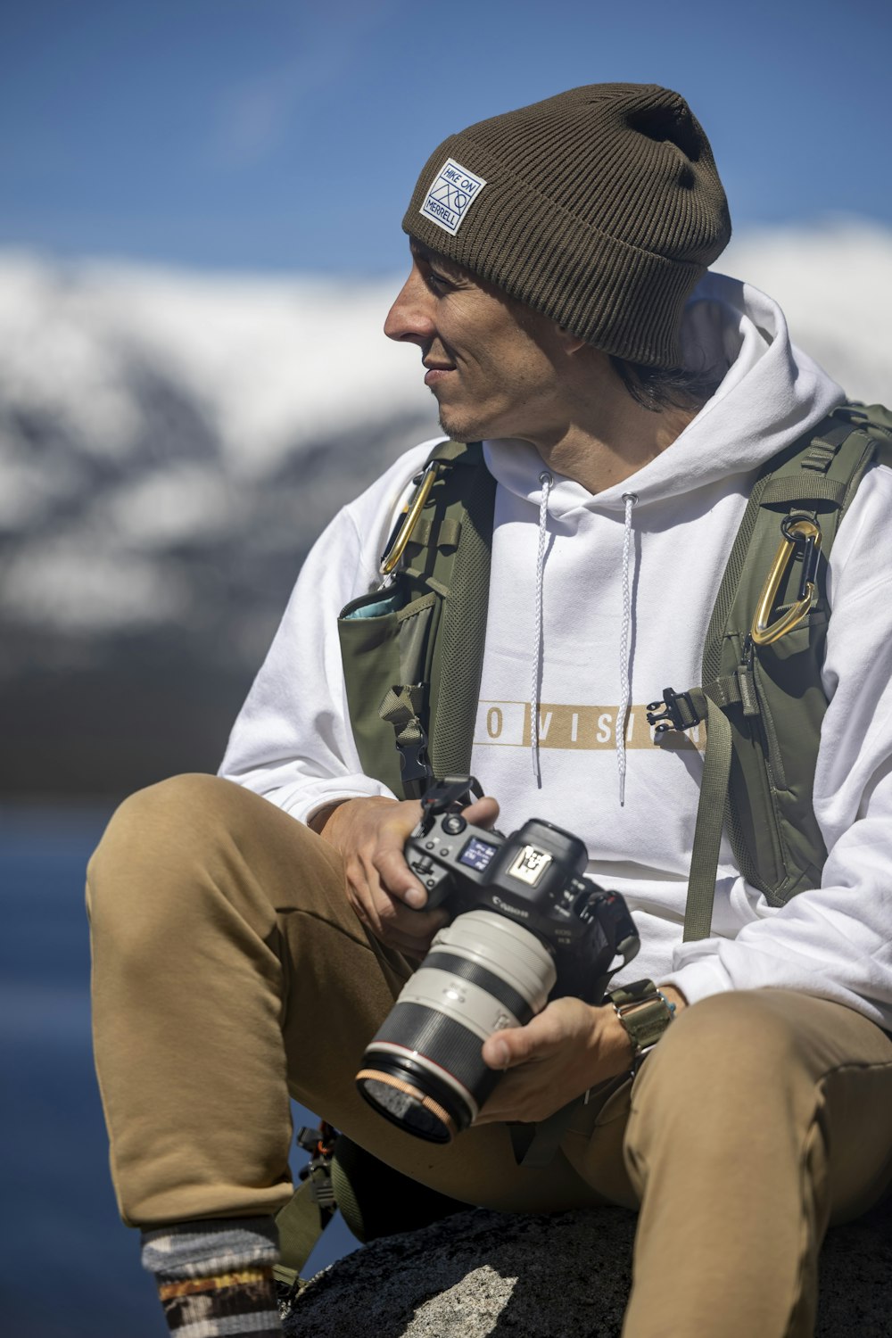 a man sitting on a rock holding a camera