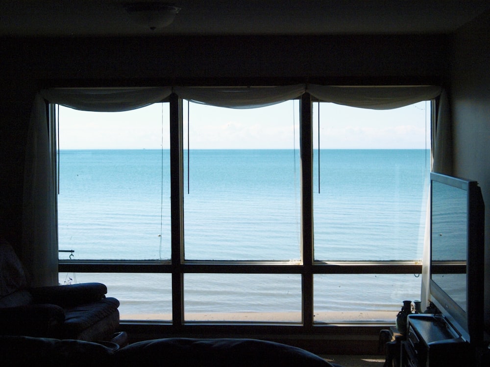 a living room with a large window overlooking the ocean