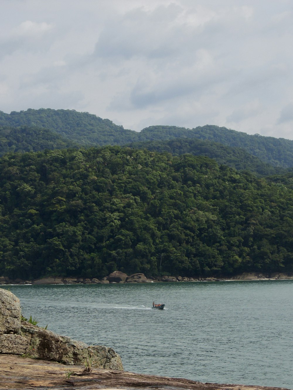 a boat is in the water near a mountain