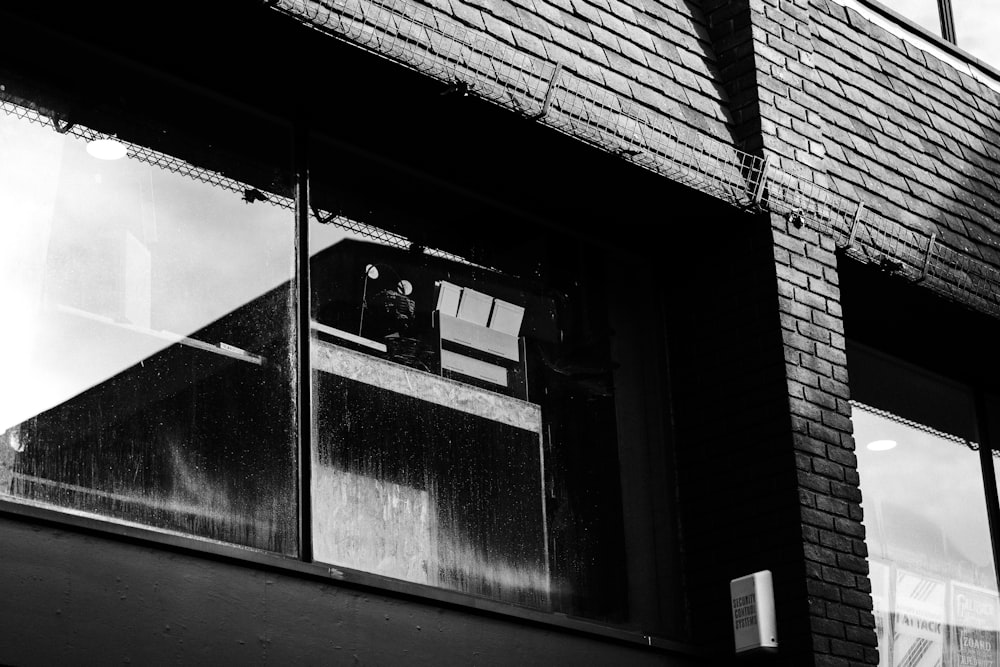 a black and white photo of a person looking out a window