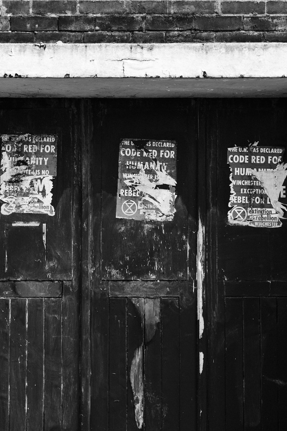 a black and white photo of two doors with signs on them