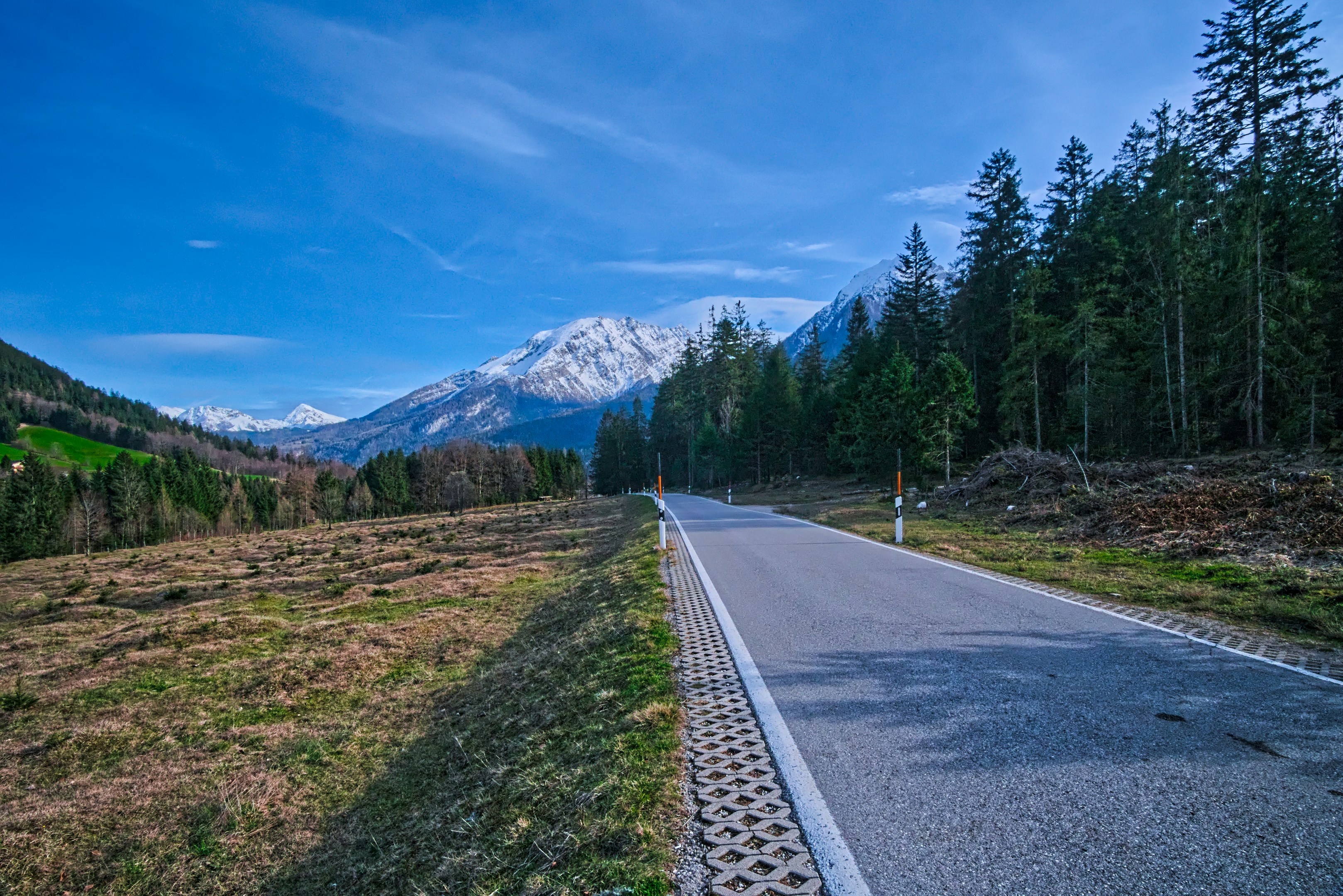 eine Straße mitten auf einem Feld mit Bergen im Hintergrund