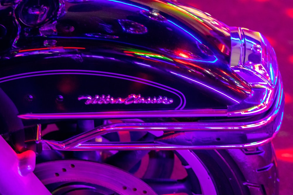 a close up of a motorcycle with a purple background