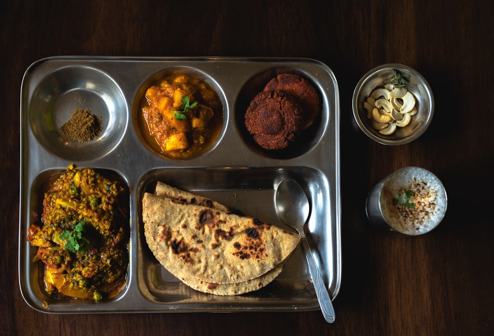 a metal tray topped with different types of food