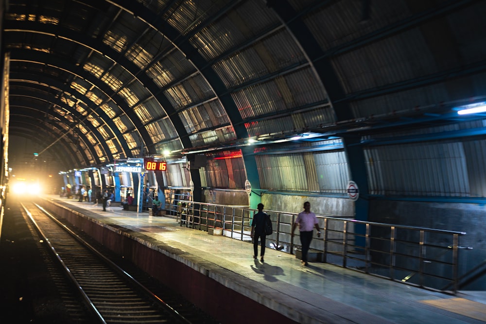 a group of people standing on a platform next to a train