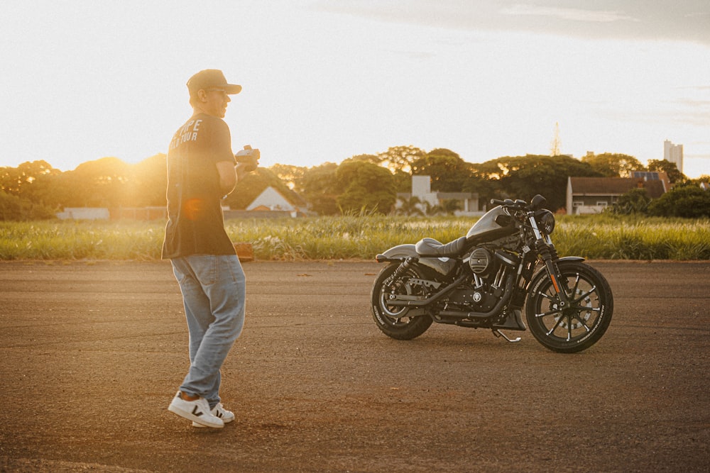 Un homme debout à côté d’une moto garée