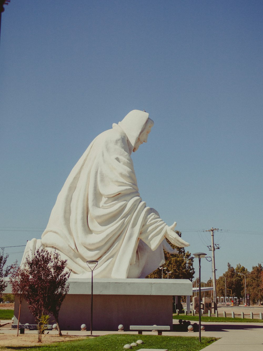 une grande statue blanche d’une personne avec un manteau blanc