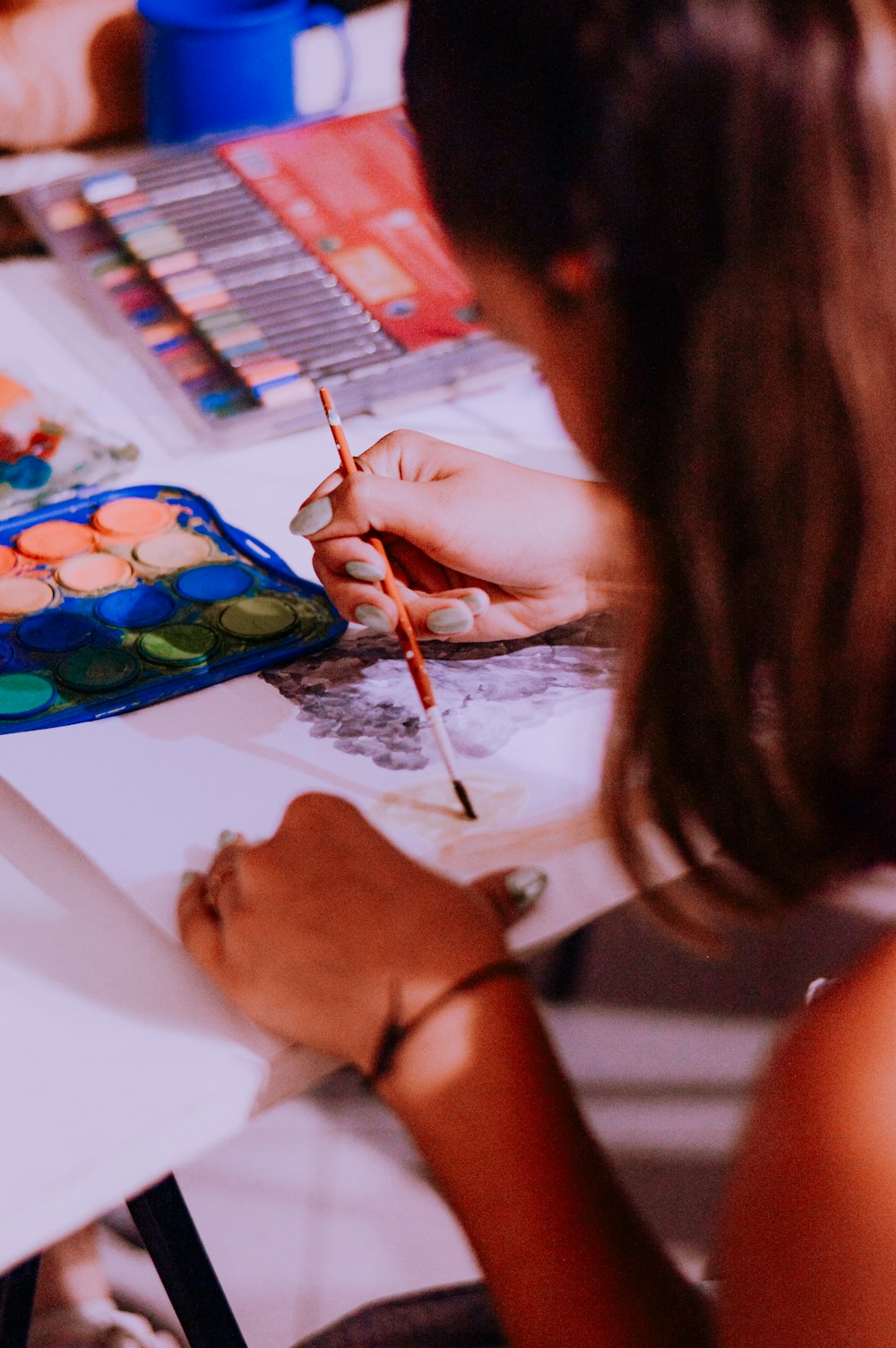 a woman sitting at a table with a pencil in her hand