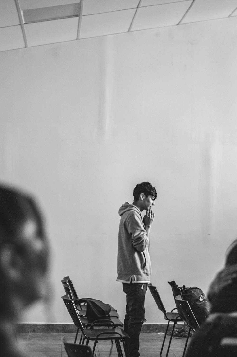 a man standing in front of a group of chairs talking on a cell phone