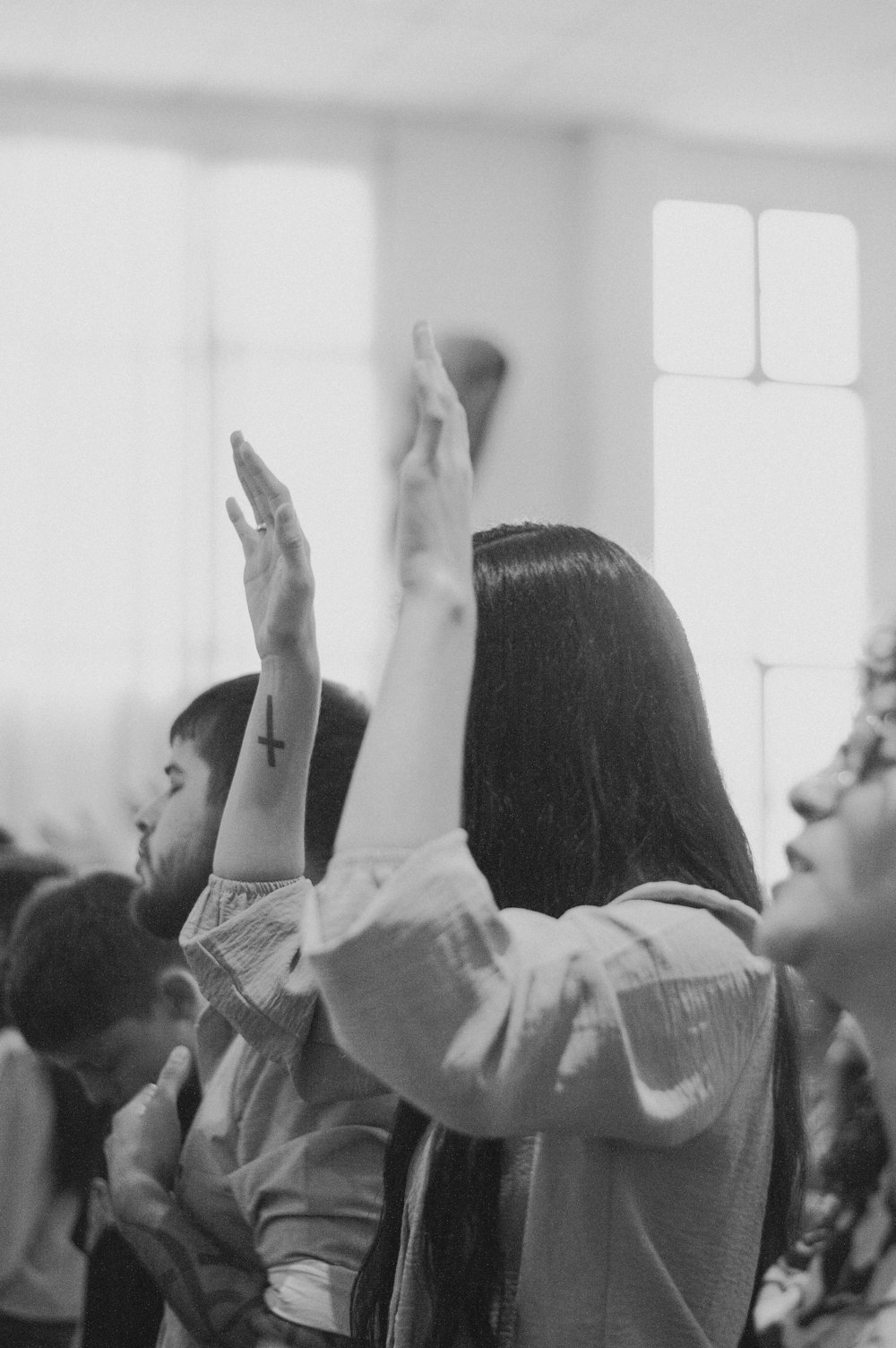 a group of people sitting in a room with their hands up