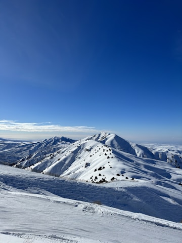 a snow covered mountain with a blue sky in the background