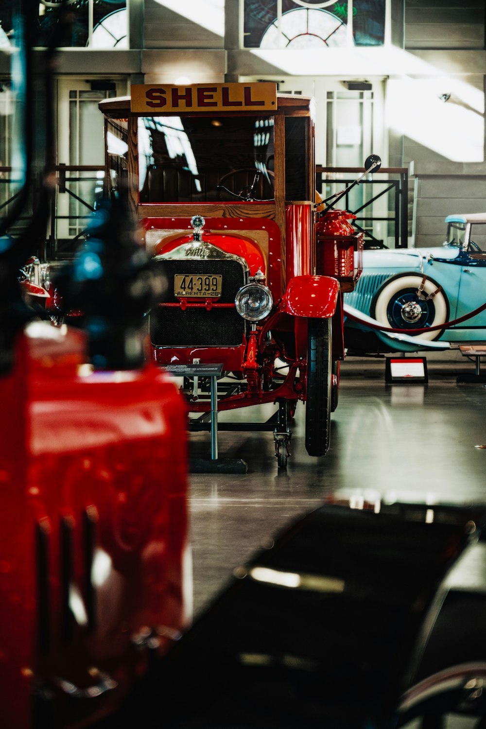 an old red car is parked in a garage