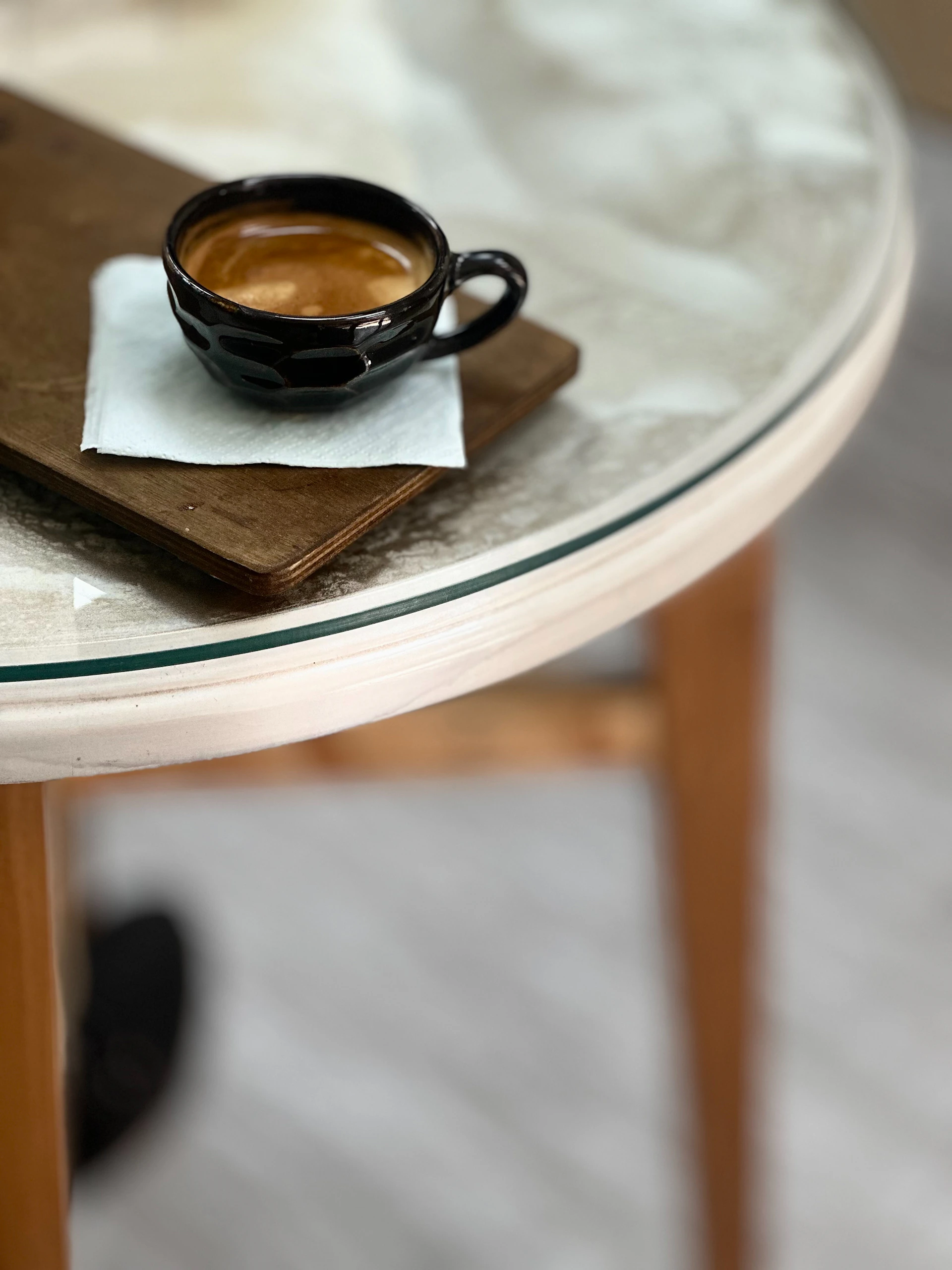 a cup of coffee sitting on top of a wooden table