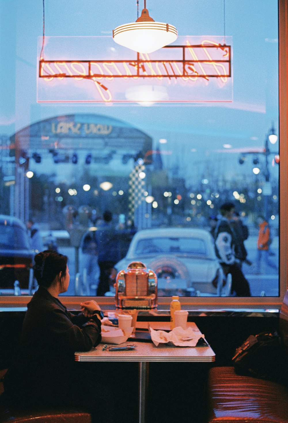 a woman sitting at a table in front of a window